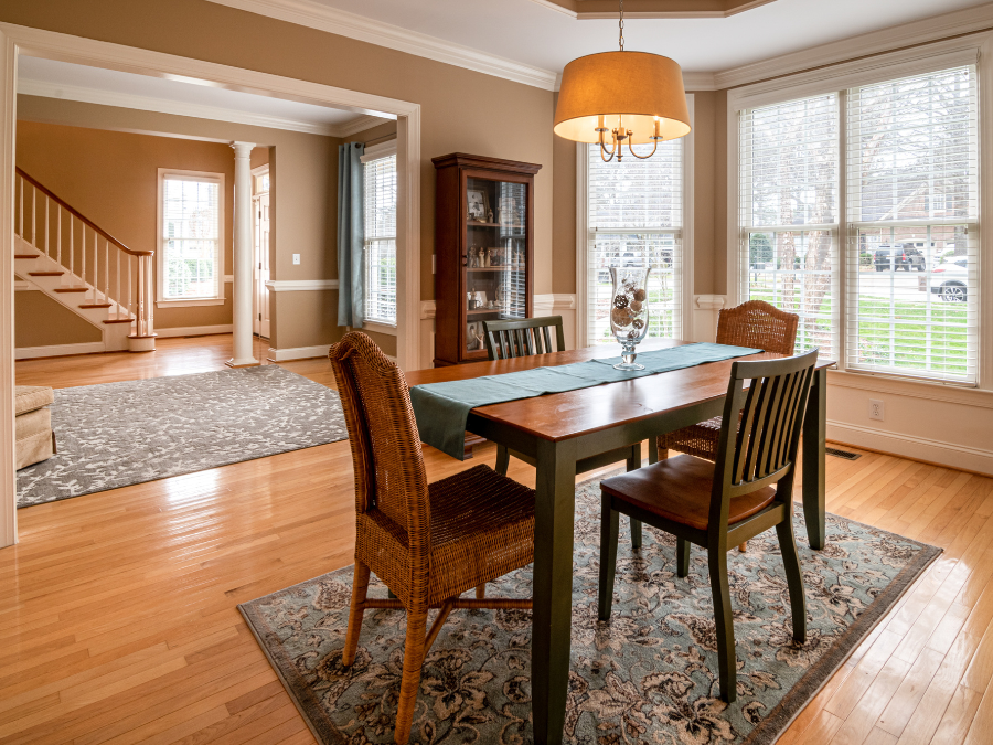 A cozy dining area with a floral-patterned rug, a wooden table, and comfortable chairs.