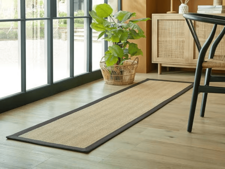 A natural fiber entryway rug placed in a bright hallway.