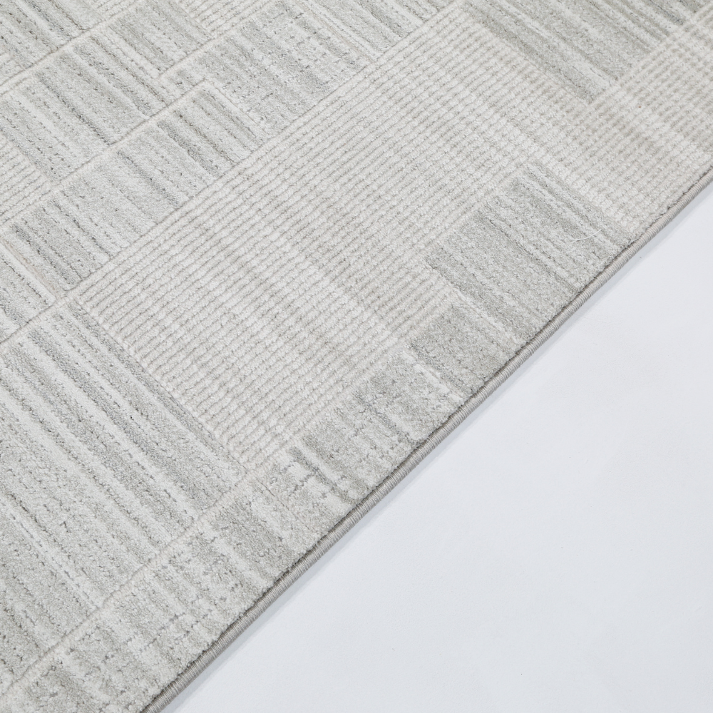 Textured neutral woven rug with geometric patterns for modern home decor.