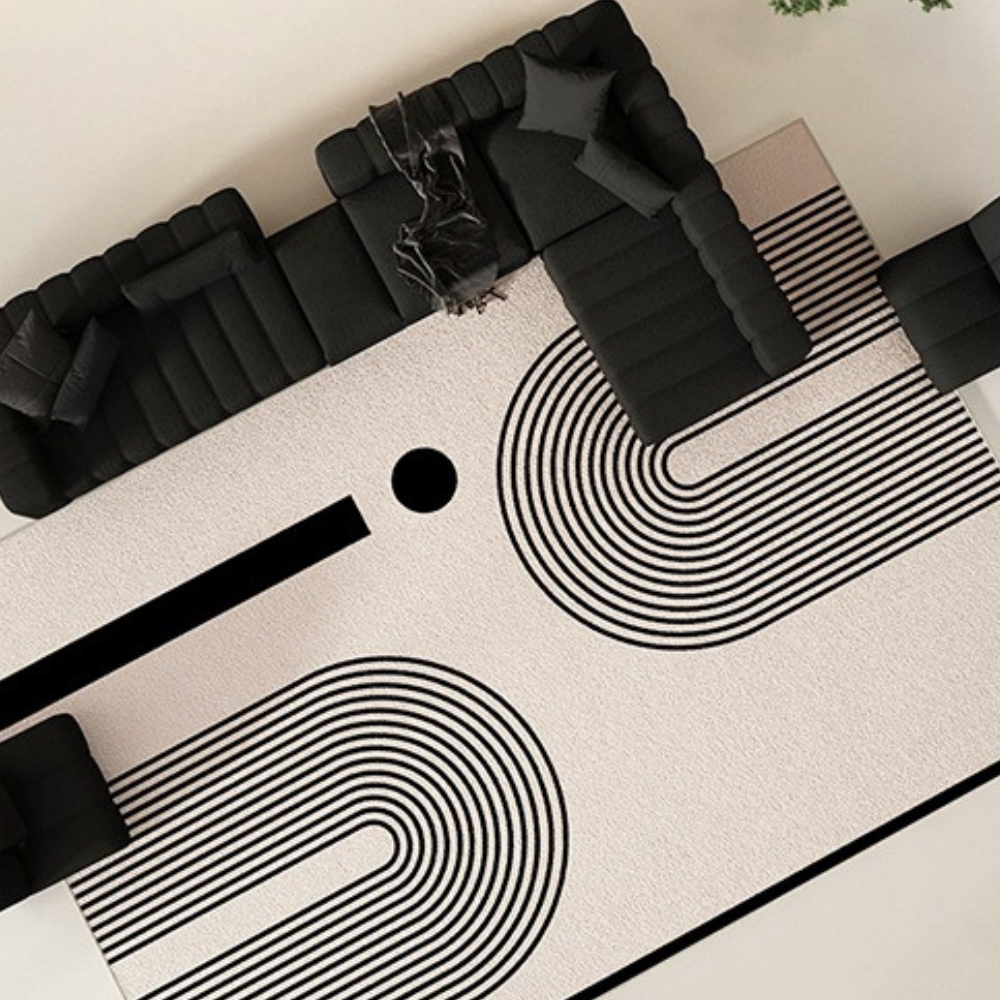 Geometric striped rug under a black sofa, perfect for contemporary home decor.