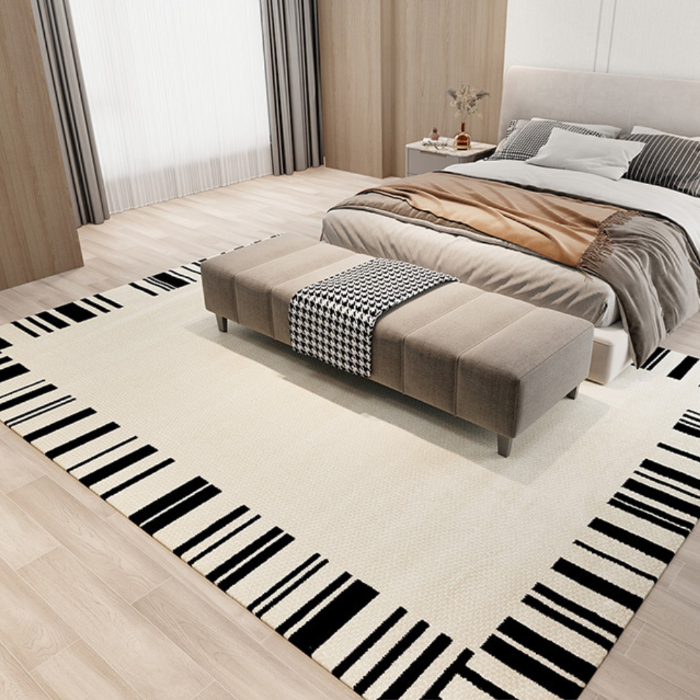 Modern cream and black bordered textured rug in a contemporary bedroom setting.