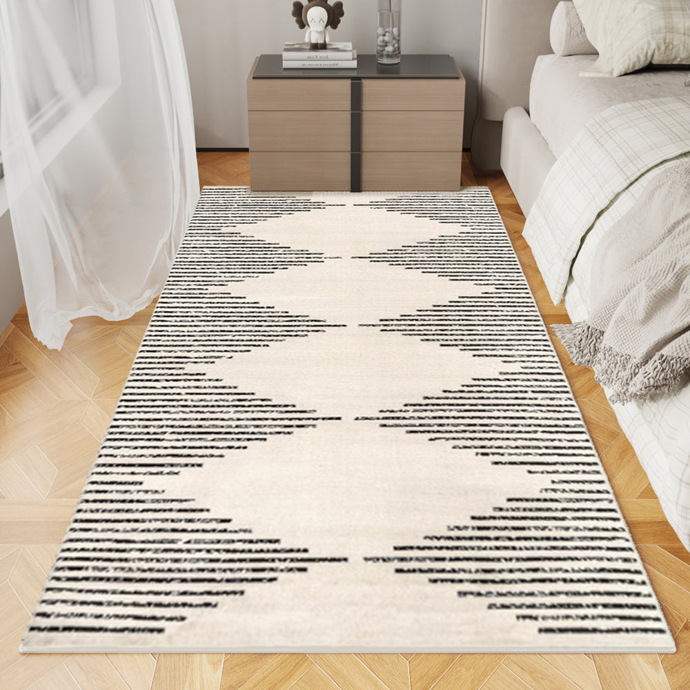 Desert Echo Geometric Rug in black and beige chevron pattern on wooden floor