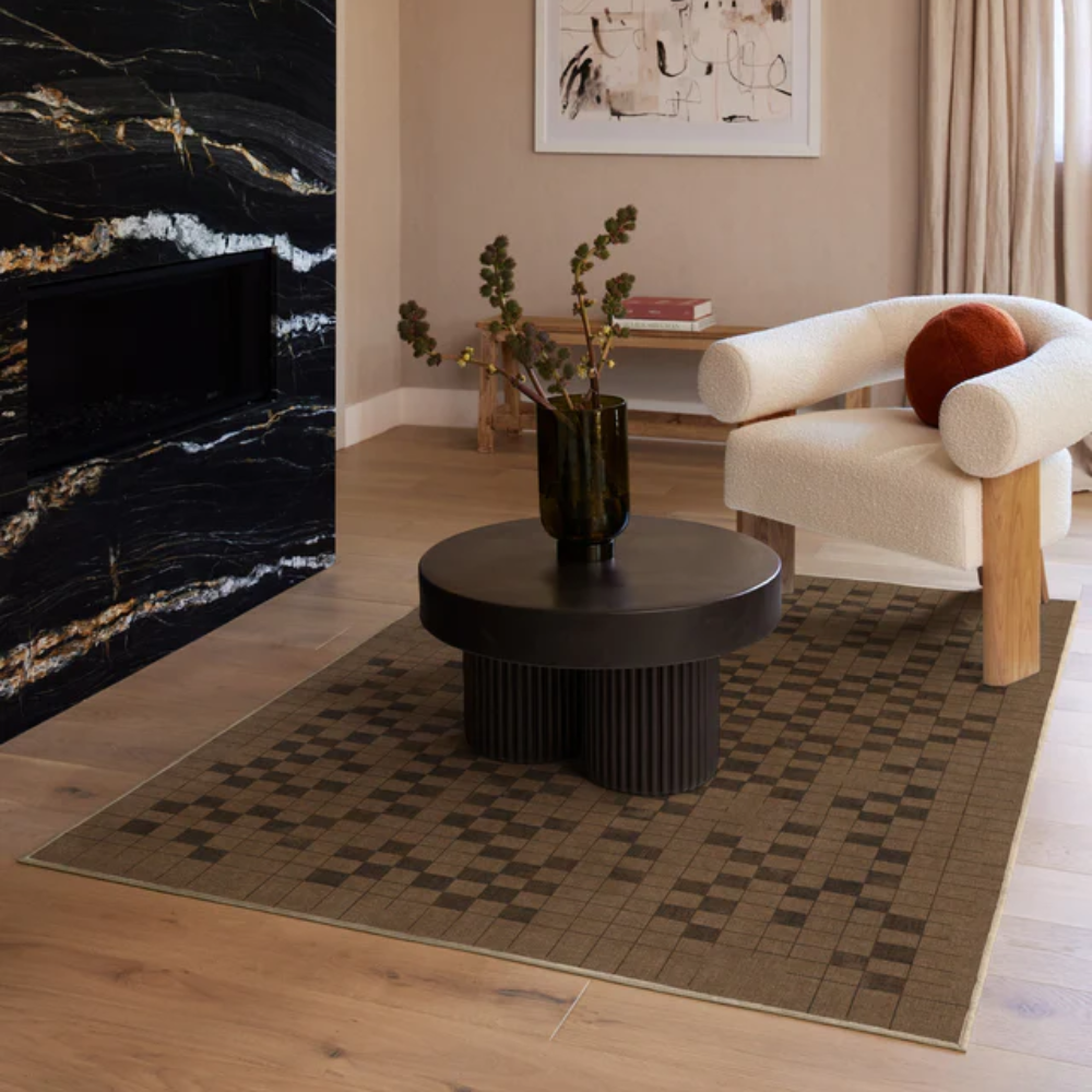 Brown geometric Elysia washable rug under a black coffee table in modern living room