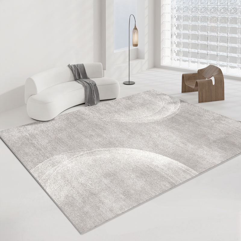 Simple Modern Seren gray rug with abstract circular patterns in a bright living room.