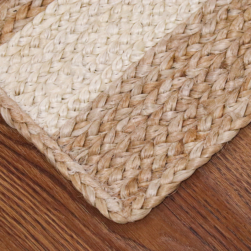 Textured beige and cream Sandy Shores outdoor woven rug corner on wooden floor.