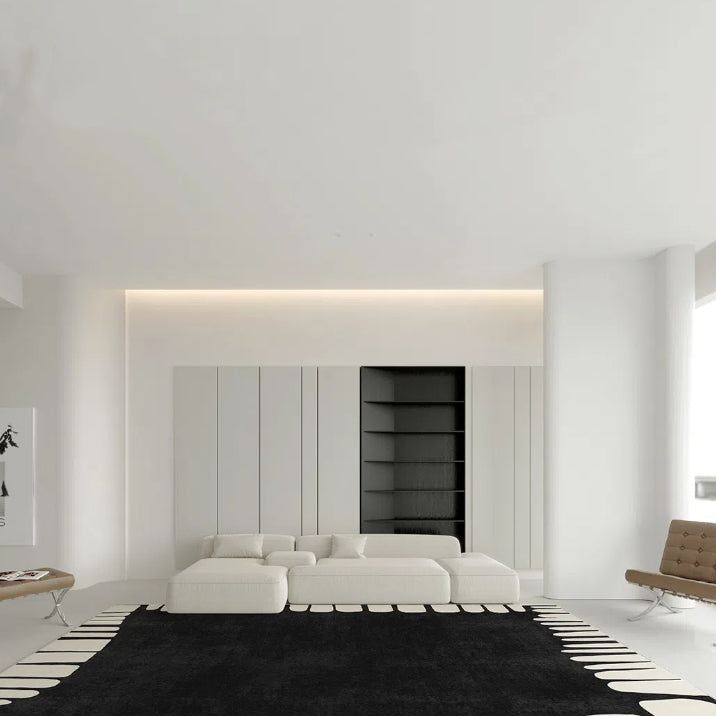 Modern black and white abstract rug in a minimalist living room setting.