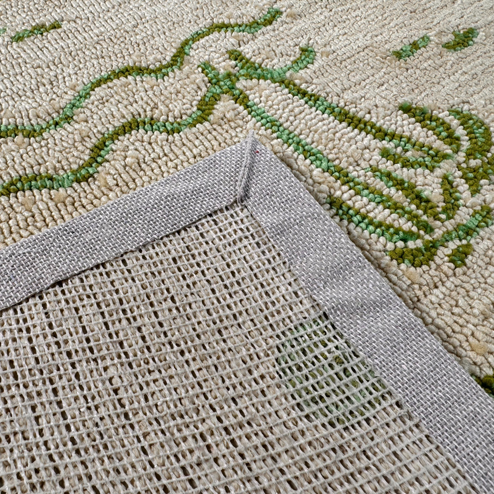 Beige rug with green palm tree design and textured border, ideal for stylish home decor.