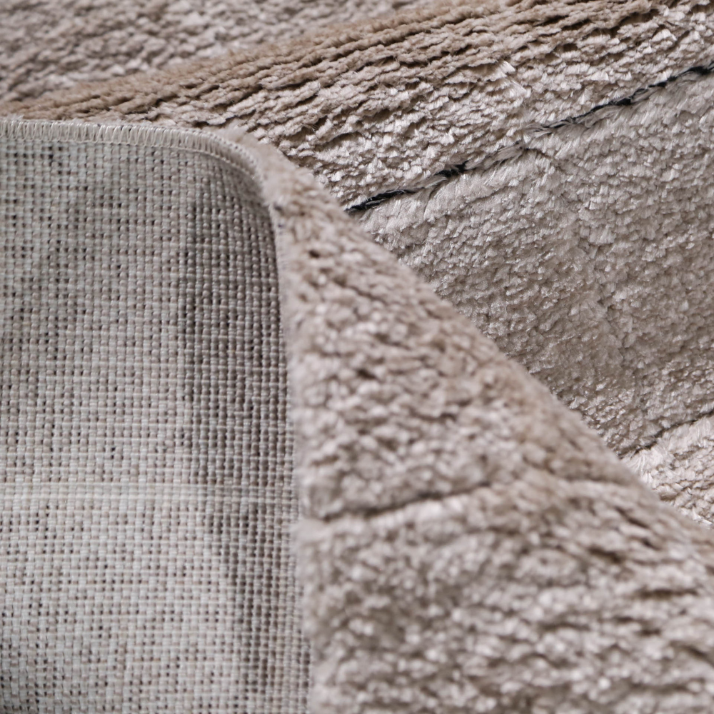 Close-up of a beige textured rug with soft fibers for stylish home decor.